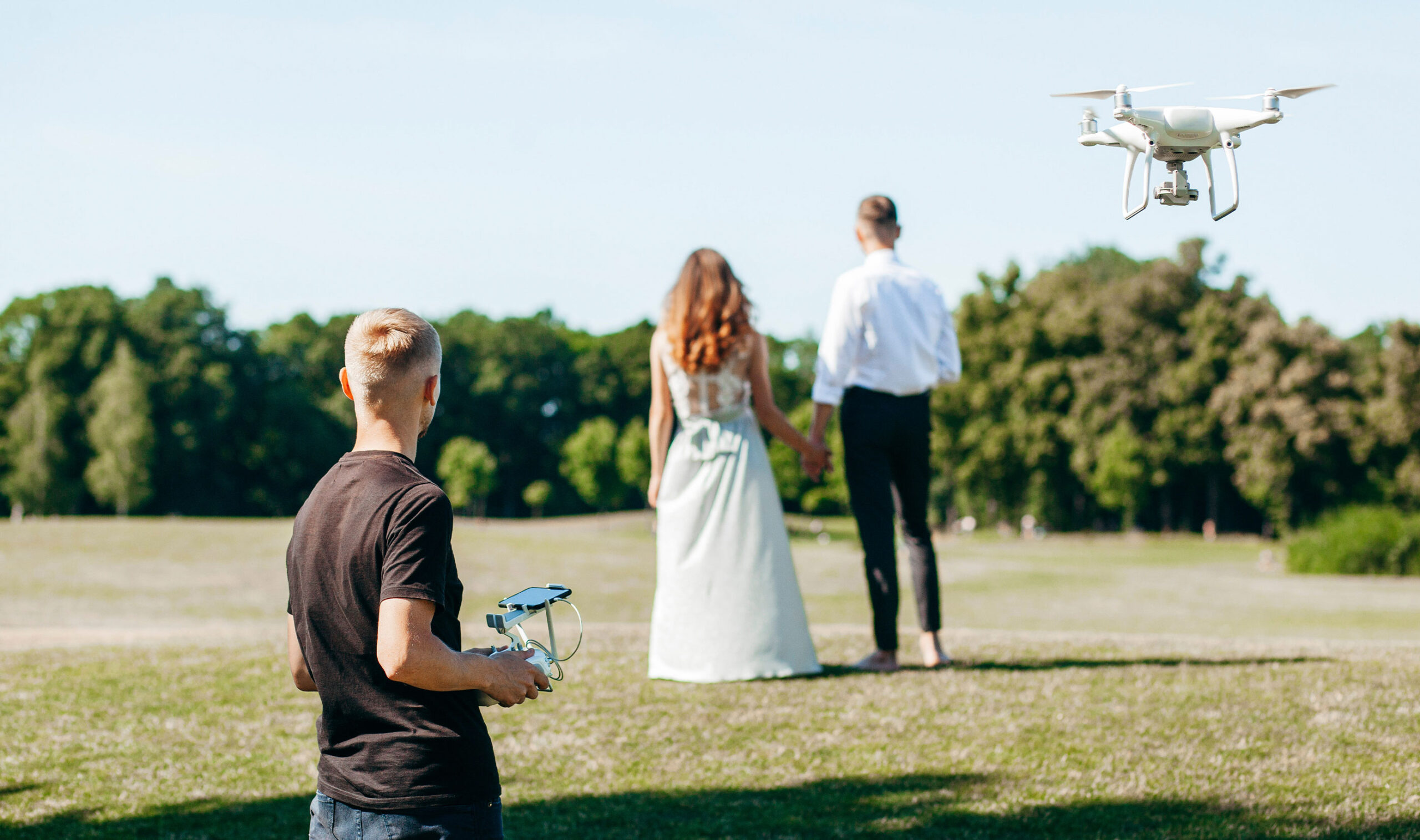 Hovering drone taking pictures of wedding couple in nature