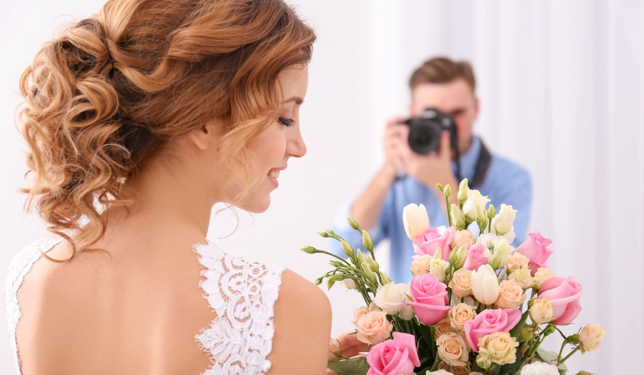 Wedding photographer taking photo of beautiful bride in studio