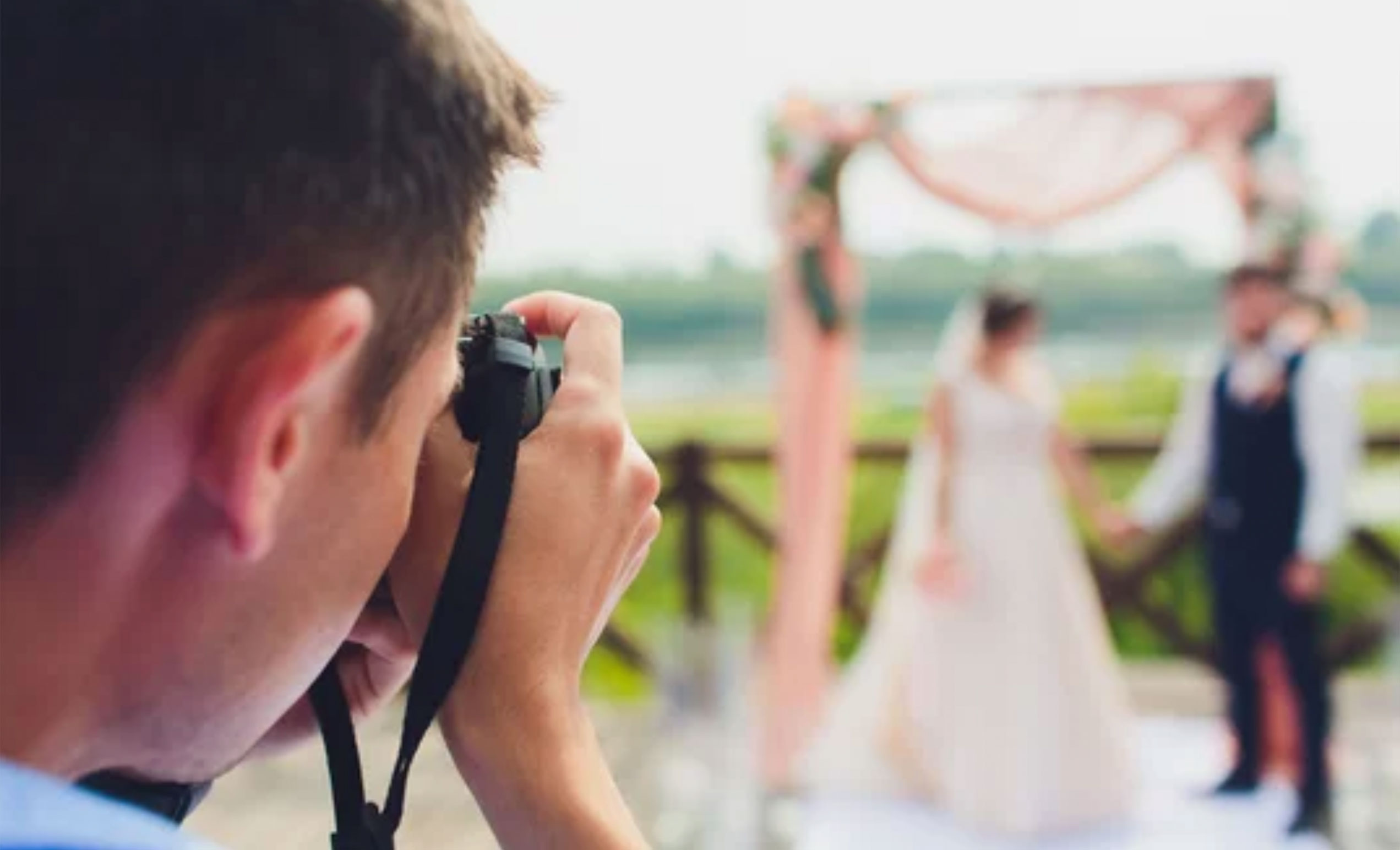 wedding photographer takes pictures of bride and groom in city. wedding couple on photo shoot. photographer in action.